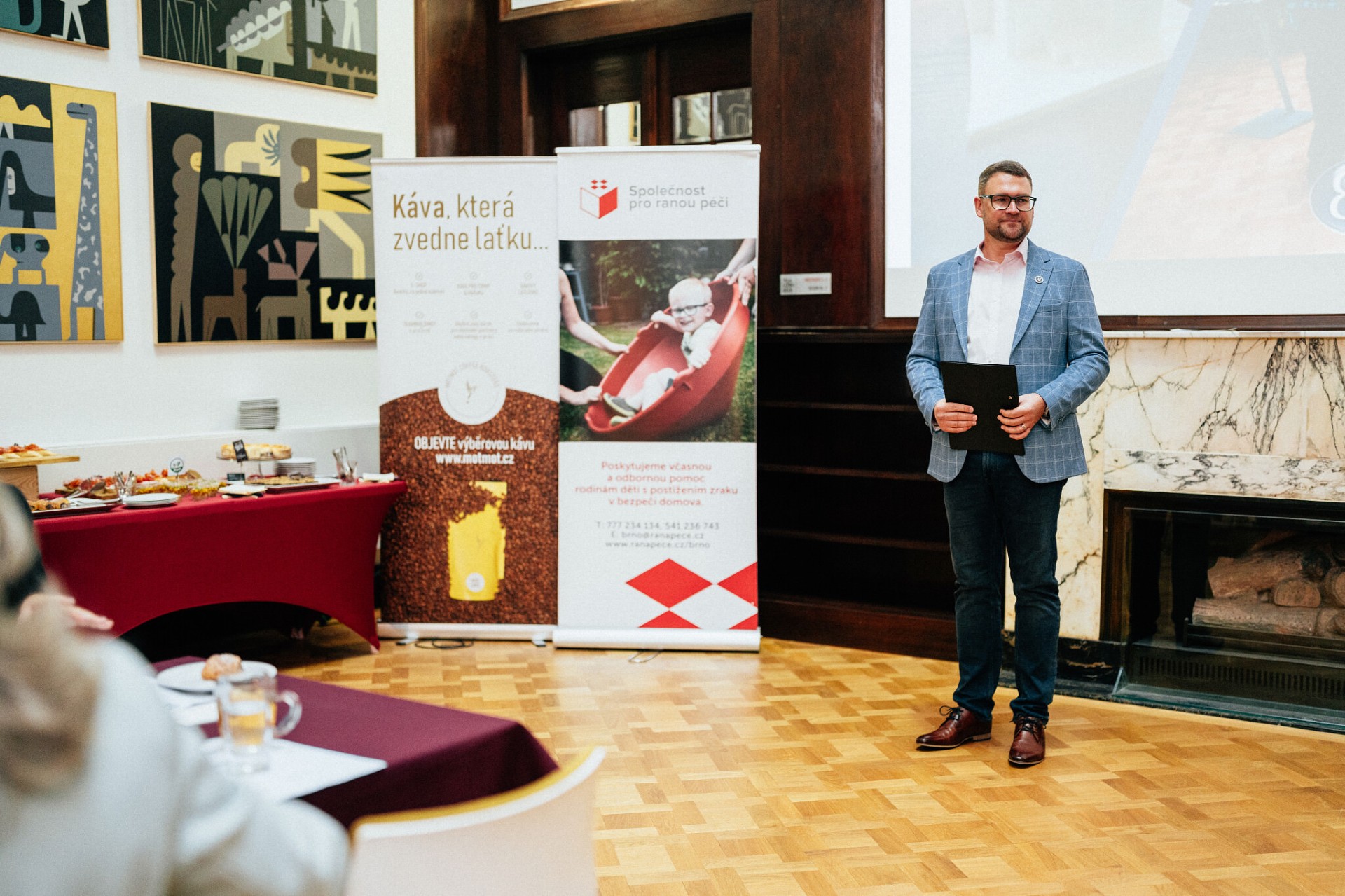 Řečník před partnerskými bannery — Meet Brno